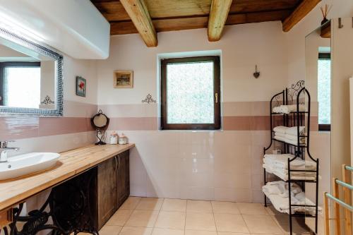 Un baño con lavabo y estante con toallas. en Domček na Staromestskej., en Banská Štiavnica