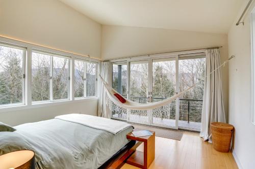 a bedroom with a hammock in front of windows at Contemporary Elka Park Retreat with Views and Deck! in Elka Park