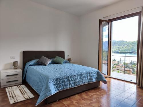a bedroom with a bed and a large window at CASA DEL SOLE in Tremezzo