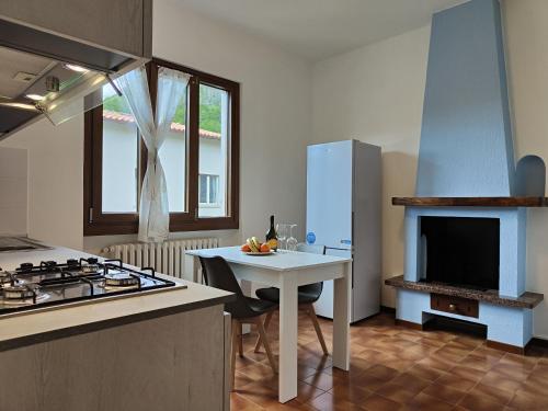 a kitchen with a stove and a sink and a table at CASA DEL SOLE in Tremezzo