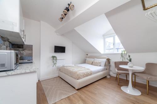 a white bedroom with a bed and a table at Arte Stays Serviced Apartments Premium Studios, Finsbury Park in London