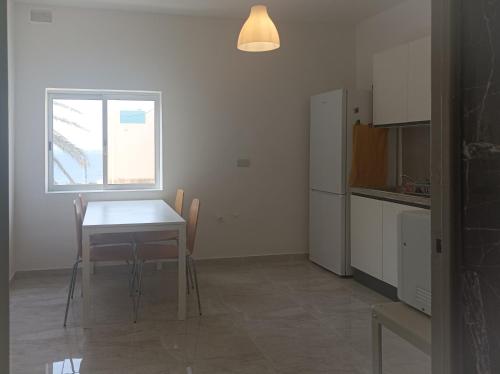 a kitchen with a table and chairs and a window at Beautiful flat with Swimming-pool & Seaview in St. Paul's Bay
