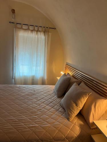 a bedroom with a large bed with a window at MeiMà Apartment Hanbury’s Gardens in Mortola Inferiore