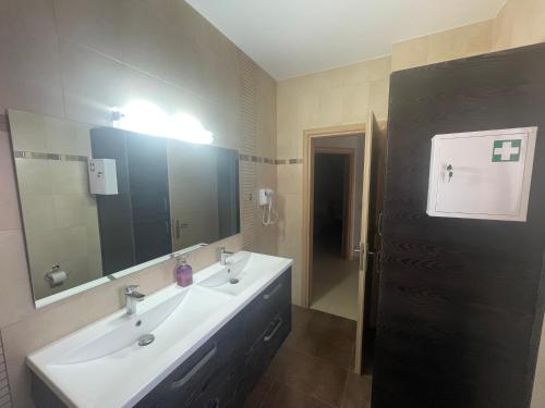 ein Badezimmer mit einem Waschbecken und einem großen Spiegel in der Unterkunft Villa Melydron in Nafplio
