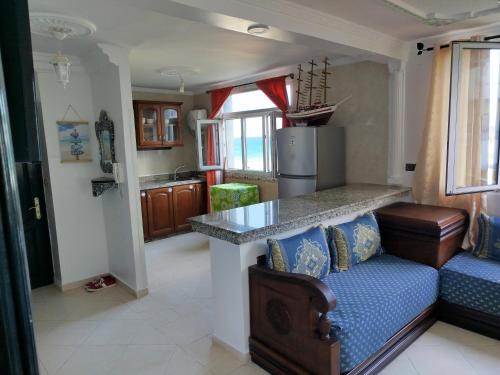 a kitchen with a couch and a counter in a room at Apartment Corniche Ksar Sgher in Ksar es Sghir