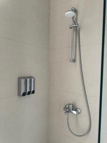 La salle de bains est pourvue d'une douche avec un pommeau de douche. dans l'établissement Green Gem Villas Palase 82A in Green Coast, à Dhërmi