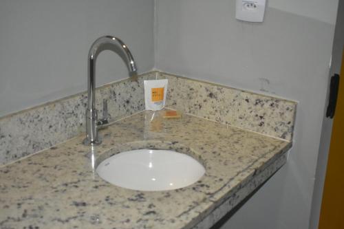 a bathroom counter with a sink with a faucet at Unity Hotel - Paulista - SP in Sao Paulo