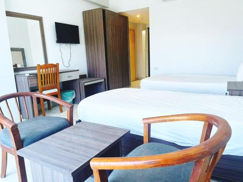 una camera con due letti e un tavolo con sedie di Cecelia Hotel Suites Hurghada a Hurghada