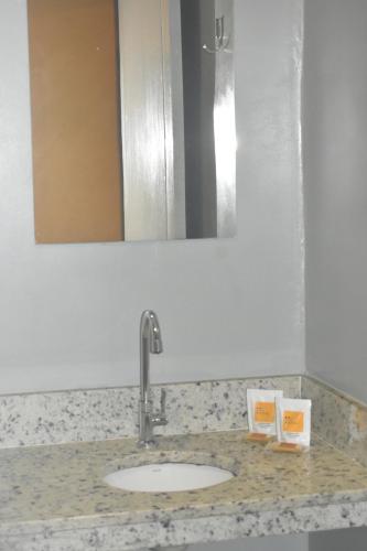a bathroom counter with a sink and a mirror at Unity Hotel - Paulista - SP in Sao Paulo