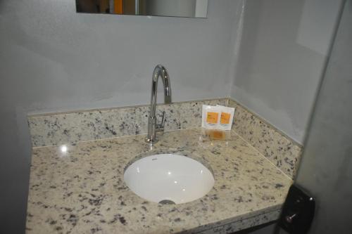 a bathroom counter with a sink with a faucet at Unity Hotel - Paulista - SP in Sao Paulo
