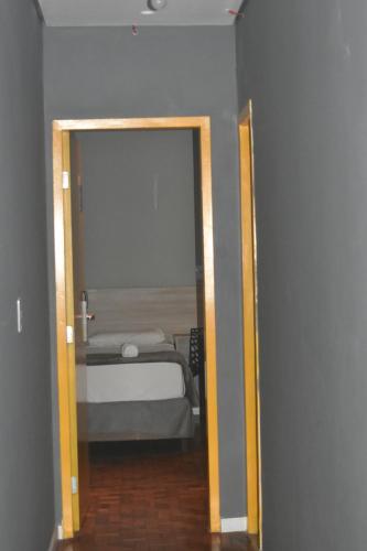 a doorway to a bedroom with a bed and a mirror at Unity Hotel - Paulista - SP in Sao Paulo