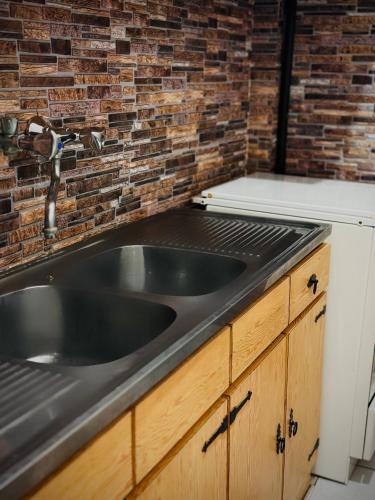 a kitchen with a sink and a brick wall at Sunlight apartment in Nea Peramos