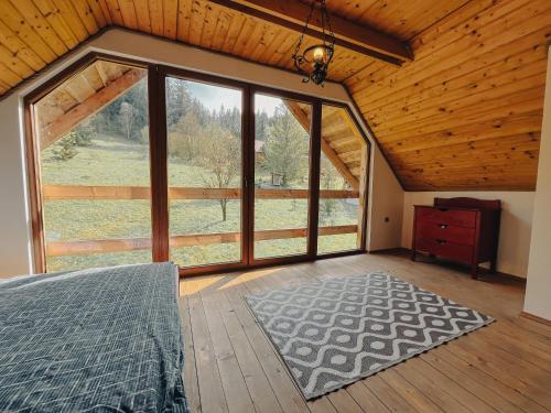 Dormitorio con ventana grande en una cabaña en Zruby Krpáčovo en Dolná Lehota
