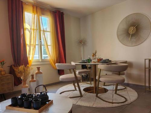 a living room with a table and chairs and a window at T2 54m² parking Cœur de Chartres in Chartres