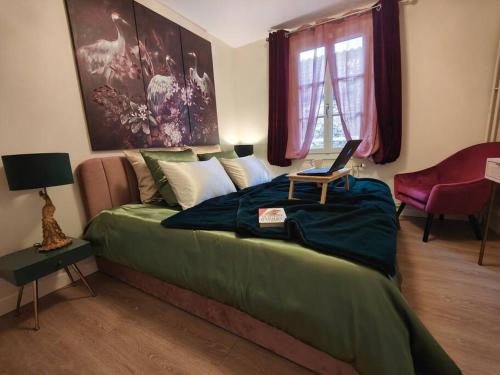 a bedroom with a bed with a laptop on it at T2 54m² parking Cœur de Chartres in Chartres