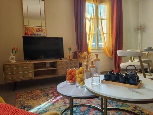 - un salon avec une télévision et une table avec des fruits dans l'établissement T2 54m² parking Cœur de Chartres, à Chartres