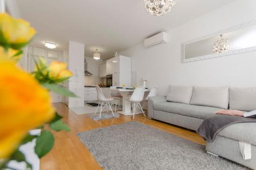 - un salon avec un canapé et une table avec des chaises dans l'établissement Apartment L&I, à Šibenik