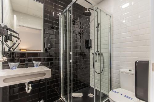 a bathroom with a shower and a sink and a toilet at Hotel Zen Airport in Torremolinos