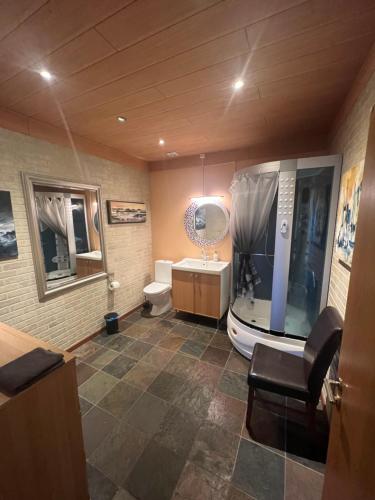 uma casa de banho com uma banheira, um WC e um lavatório. em Fisherinn, Hostel and Cultural Center em Stokkseyri