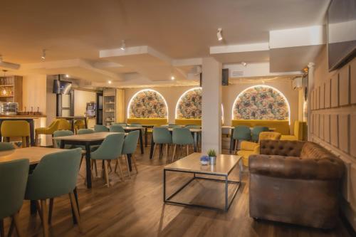 a dining room with tables and chairs and windows at Hotel Zen Airport in Torremolinos