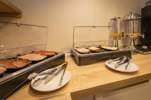 a counter with plates and utensils in a kitchen at Hotel Zen Airport in Torremolinos