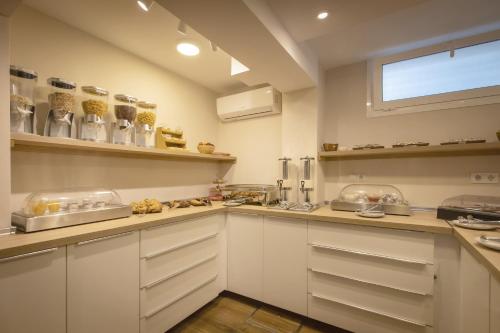 a large kitchen with white cabinets and a window at Hotel Zen Airport in Torremolinos