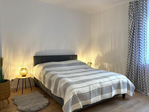 - une chambre avec un lit et une couverture rayée dans l'établissement 3 Zimmer Apartment - Nähe Klinikum & Altstadt - Parken, WLAN, Waschmaschine, à Amberg