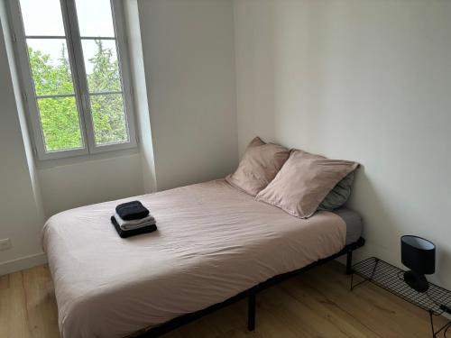 - une petite chambre avec un lit et un livre dans l'établissement Havre de paix au sein d'un T3 d'une bastide aixoise, à Aix-en-Provence