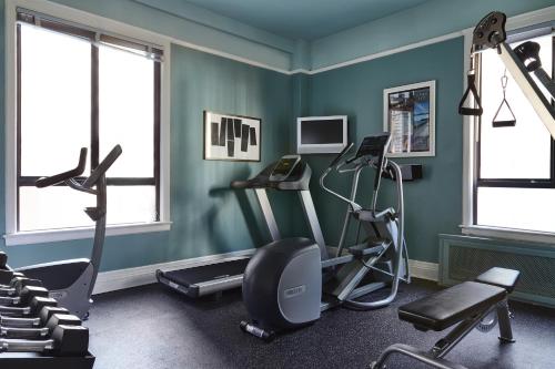un gimnasio con máquinas de ejercicio en una sala con paredes verdes en Galleria Park Hotel, en San Francisco