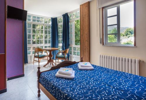ein Schlafzimmer mit einem Bett mit zwei Handtüchern darauf in der Unterkunft Pensión Castro Parrillada in Samos