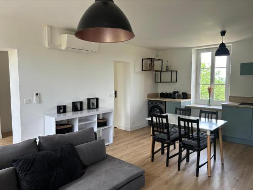 un salon avec un canapé, une table et des chaises dans l'établissement Havre de paix au sein d'un T3 d'une bastide aixoise, à Aix-en-Provence