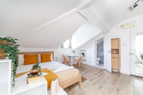 a white bedroom with a bed and a table at Arte Stays Serviced Apartments Premium Studios, Finsbury Park in London