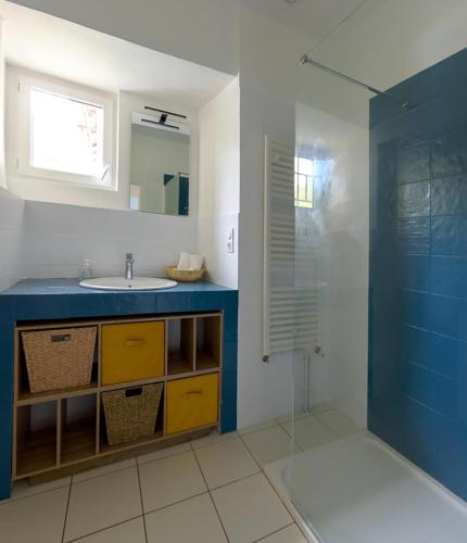 une salle de bain avec un lavabo et une douche en verre dans l'établissement Les Gîtes de la Vallée du Céou, à Gourdon