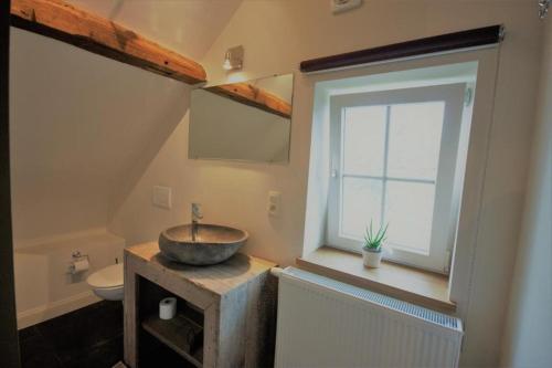 La salle de bains est pourvue d'un lavabo, de toilettes et d'une fenêtre. dans l'établissement B&B Crijbohoeve, à Zutendaal