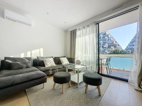 un salon avec un canapé et une vue sur l'océan dans l'établissement Appartement spacieux 2 chambres proche mer, à La Grande Motte