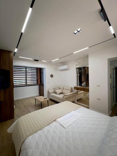 a bedroom with a large bed and a couch at Aria's Apartments in Elbasan