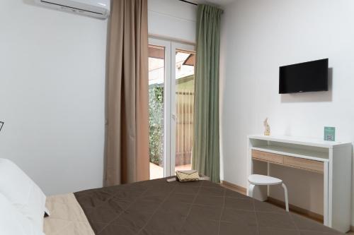 拿坡里的住宿－Benincasa Rooms Napoli，一间卧室设有一张床、一台电视和一个窗口。