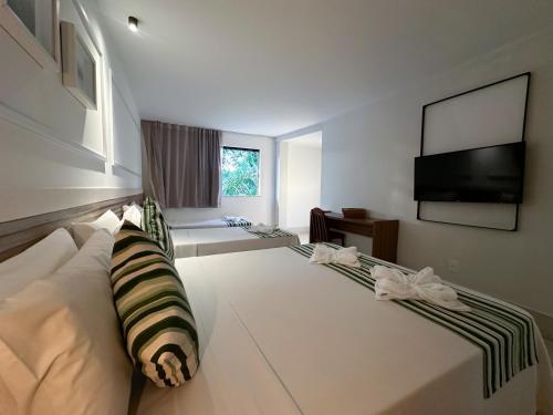 a living room with a couch and a flat screen tv at Passagem Concept Hotel e Spa in Cabo Frio