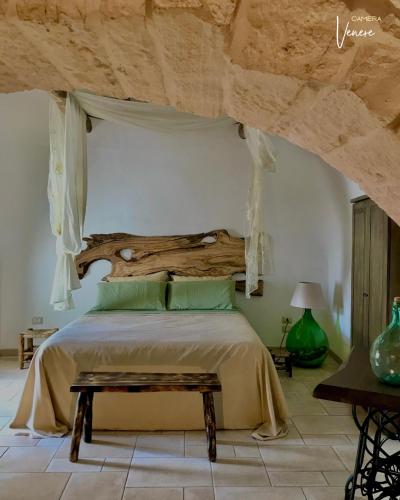 - une chambre avec un grand lit et une tête de lit en bois dans l'établissement Trullo Galileo, à Alberobello
