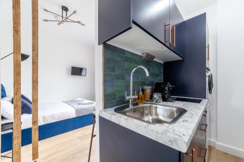 a small kitchen with a sink and a bunk bed at Arte Stays Serviced Apartments Premium Studios, Finsbury Park in London