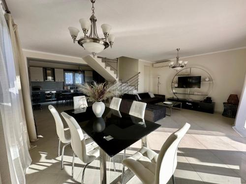 una sala da pranzo e un soggiorno con tavolo e sedie di Sunset Villa a Hanioti