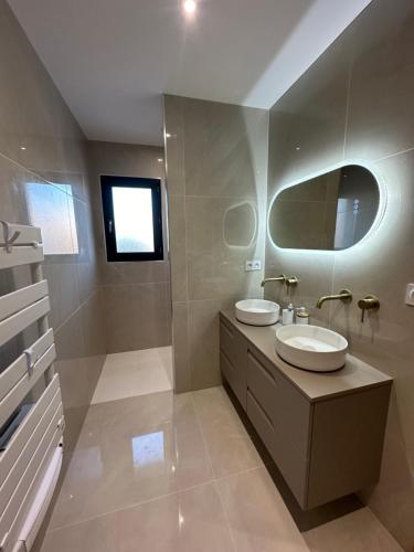 une salle de bain avec deux lavabos et un miroir dans l'établissement Villa Soleada, à Lespignan