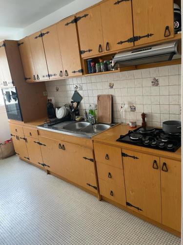 une cuisine avec des armoires en bois et un évier dans l'établissement 6p flat 12mn metro to St Lazare Paris city center, à Colombes