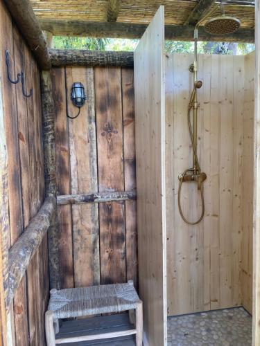 a shower with a bench in a wooden wall at Três figos Caravan in São Luis