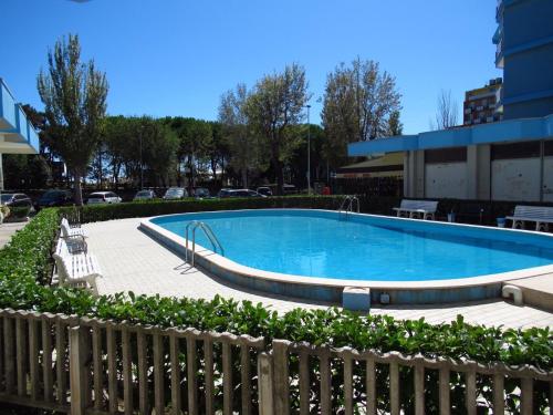 a swimming pool in front of a building at Bright wide flat, 130m from the beach with shared pool in Porto Santa Margherita di Caorle
