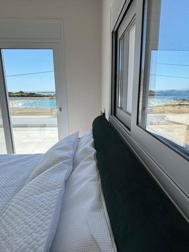 a bedroom with a bed and a large window at BEACH WHITE VILLAs in Minia