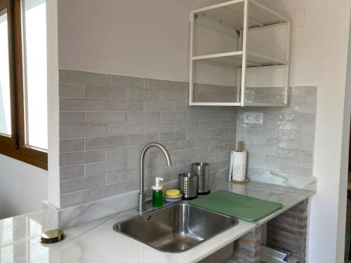 - une cuisine avec un évier et un comptoir dans l'établissement L57 - Habitaciones en Órgiva, à Órgiva
