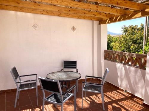 d'une terrasse avec une table et des chaises sur un balcon. dans l'établissement L57 - Habitaciones en Órgiva, à Órgiva