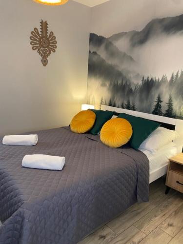 1 dormitorio con 1 cama con 2 almohadas amarillas en Apartament pod Smrekiem, en Zakopane