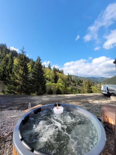 a hot tub with a candle in the middle at Cucu Zen Cazare Cabane Pensiuni Bucovina 